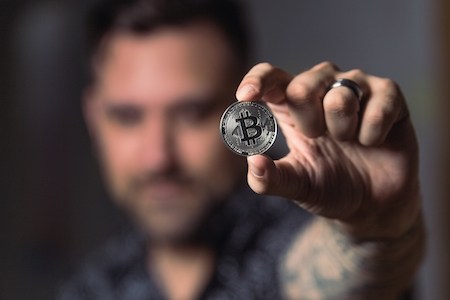 Man showing a bitcoin coin